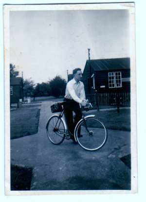 Man stood with a bicycle.